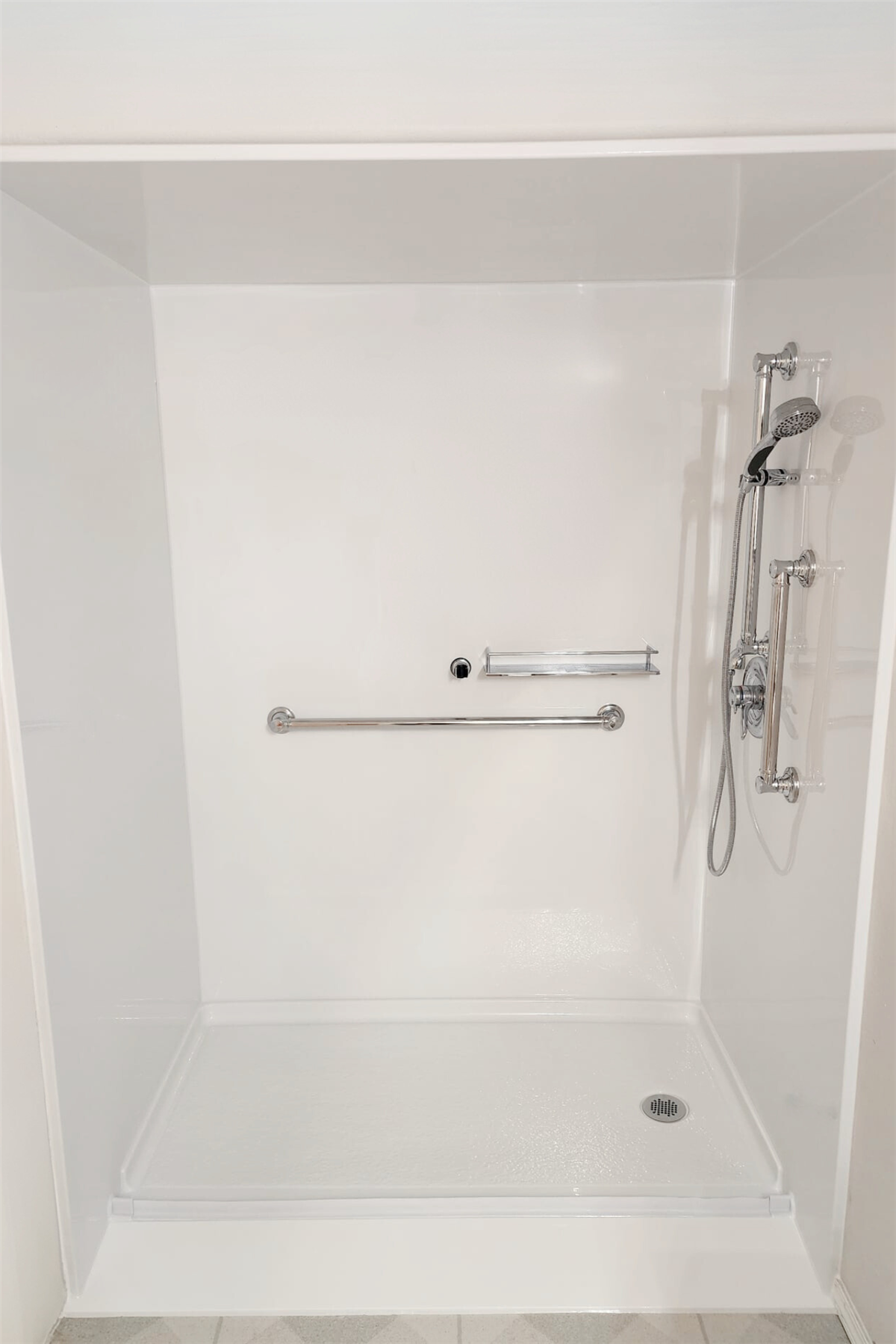 Barrier-free shower wall with stainless steel safety grab bars and accessible controls