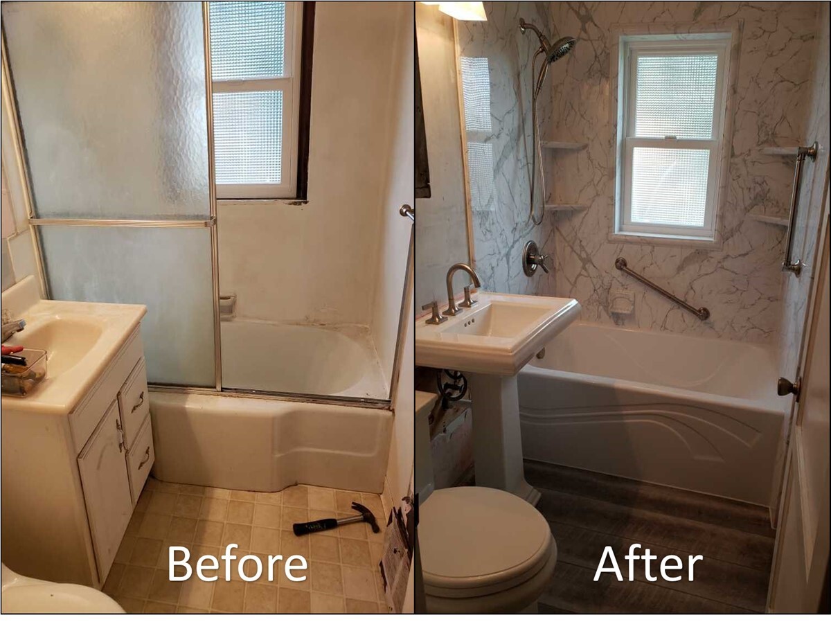 Bathroom remodeling project in progress with bathtub, sink, and exposed wall framing