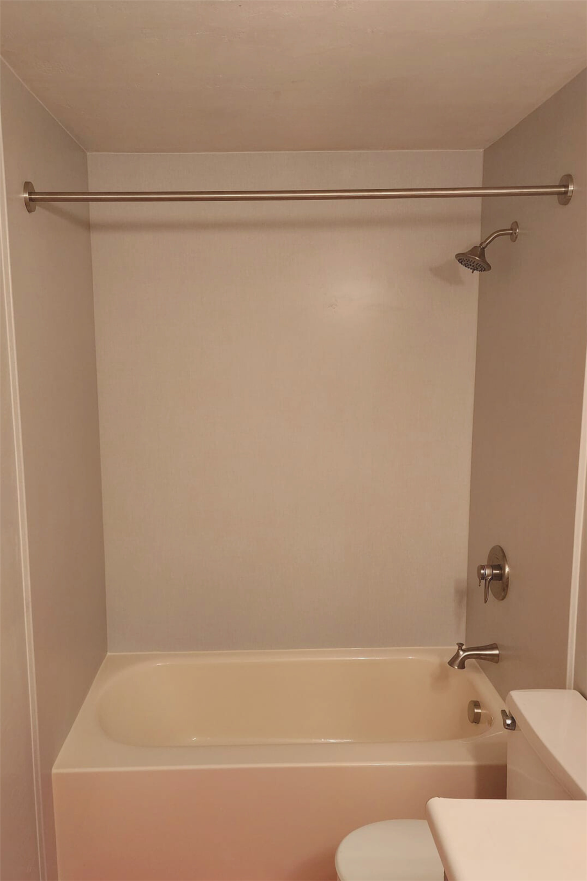 New bathtub with smooth beige wall surround