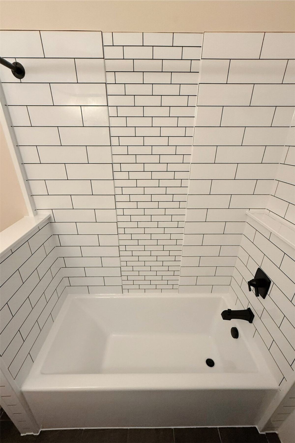 Replacement bathtub with white subway tile walls and decorative accent pattern