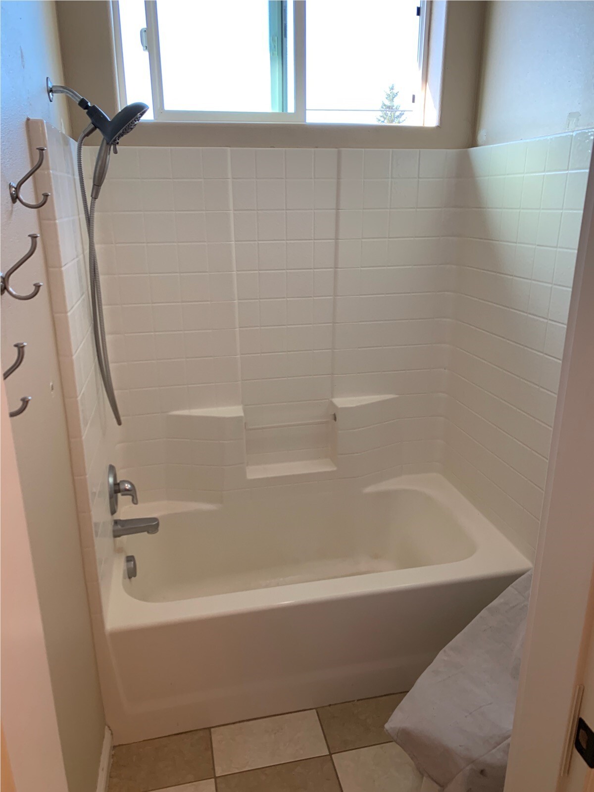 White bathtub surround with built-in shelves after bathroom remodeling