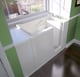 Accessible walk-in bathtub with outward-opening door and contoured interior seat