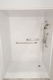 Barrier-free shower wall with stainless steel safety grab bars and accessible controls