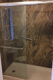 Dark stone-look walk-in shower with glass enclosure and safety grab bar