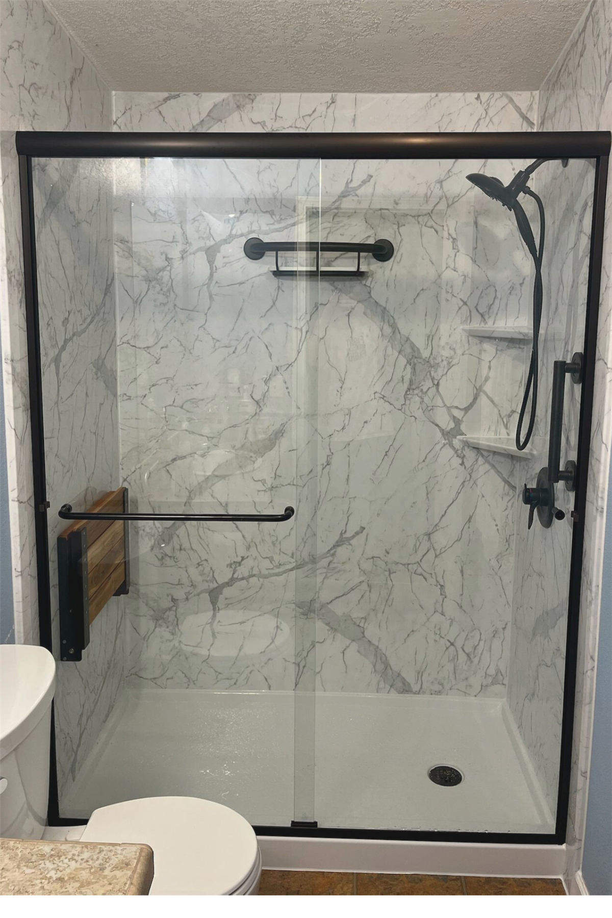 Marble-look tub-to-shower conversion with stainless steel safety grab bar