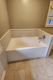 New white replacement tub with light gray tile-look wall surround