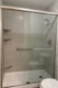 Remodeled shower with gray wall panels and horizontal stainless steel grab bars
