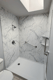 remodeled-shower-with-white-marble-look-walls-and-stainless-10a3354f