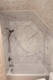 White bathtub with marble-look wall panels